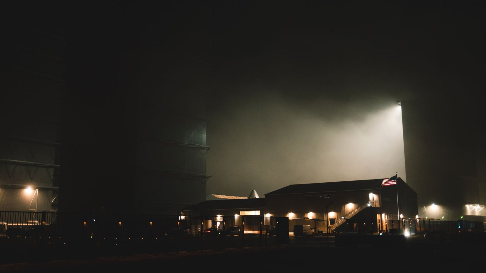 Piste d'aéroport dans le brouillard avec balises lumineuses allumées la nuit