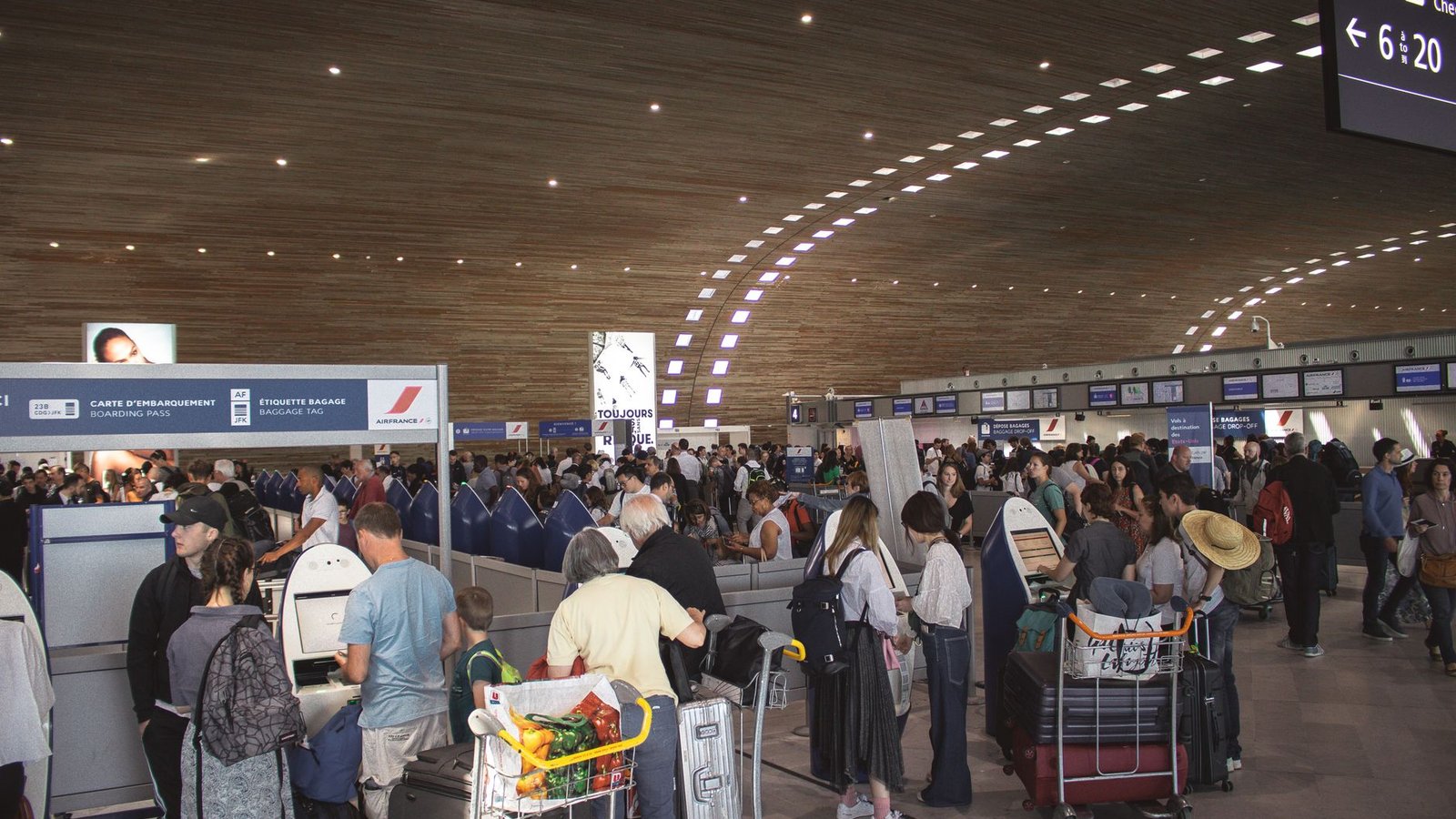 Agent aéroport vérifiant le poids d'un bagage au comptoir
