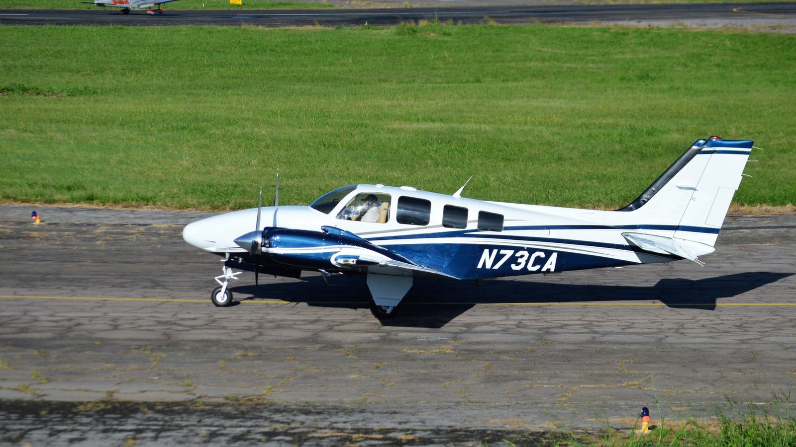 Petit avion sur la piste de l'aéroport de Gisborne en Nouvelle-Zélande, avec la voie ferrée visible en travers