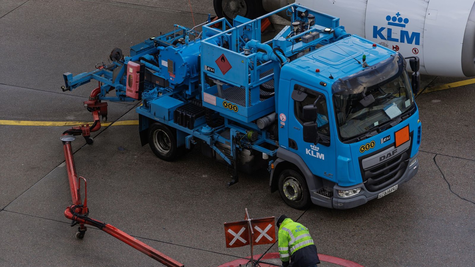 Camion-citerne en train de ravitailler un avion de ligne sous l'aile