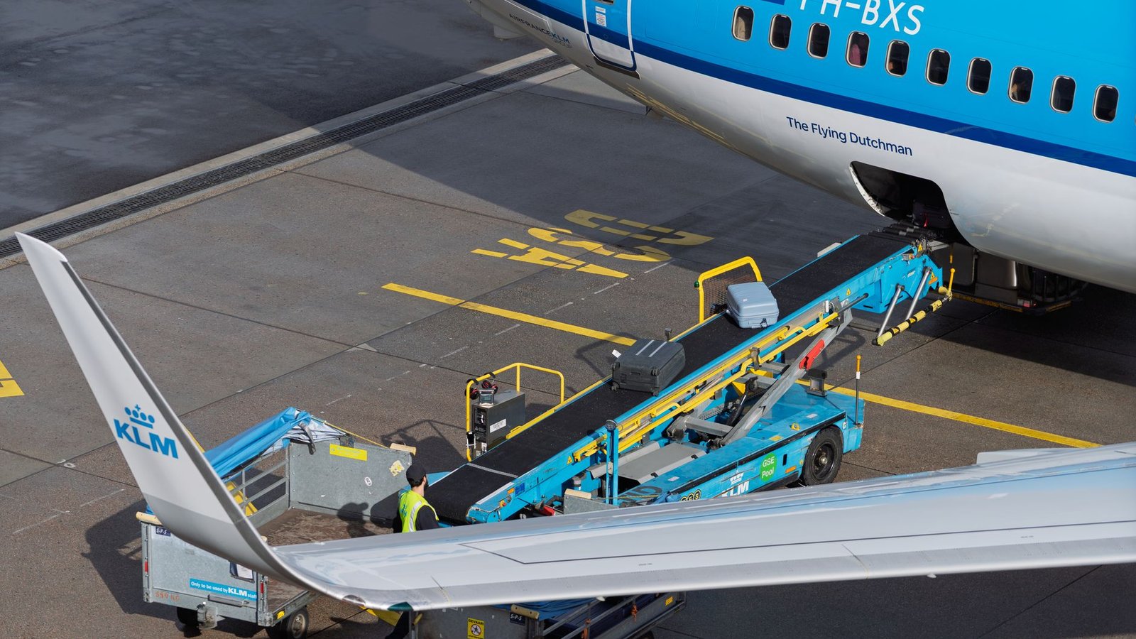 Manutentionnaires déchargeant des bagages de la soute d'un avion sur le tarmac