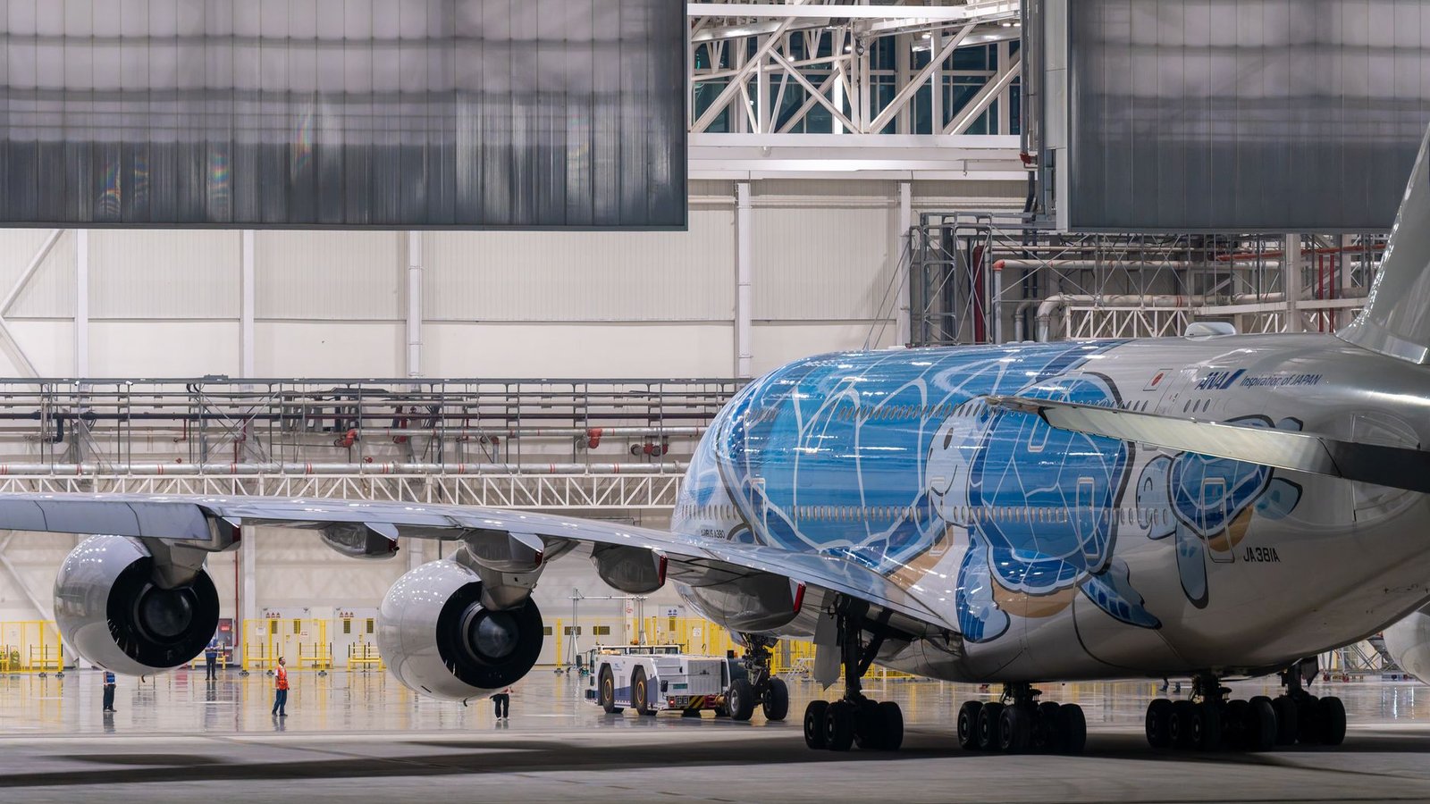 Technicien inspectant un réacteur d'avion commercial dans un hangar de maintenance