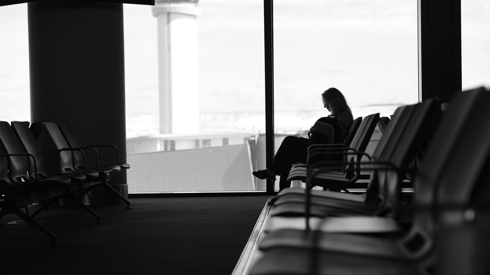 Passagers assis qui attendent dans un terminal d'aéroport